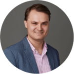 Mats Varre Sandøy smiler til kamera med blå dressjakke og rosa skjorte.