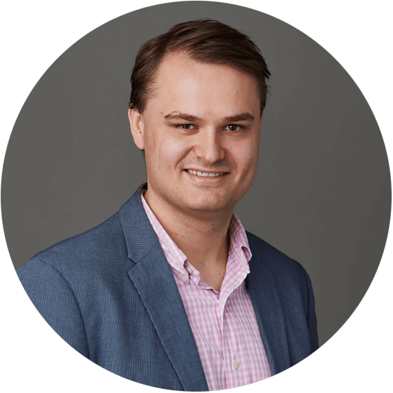 Mats Varre Sandøy smiler til kamera med blå dressjakke og rosa skjorte.